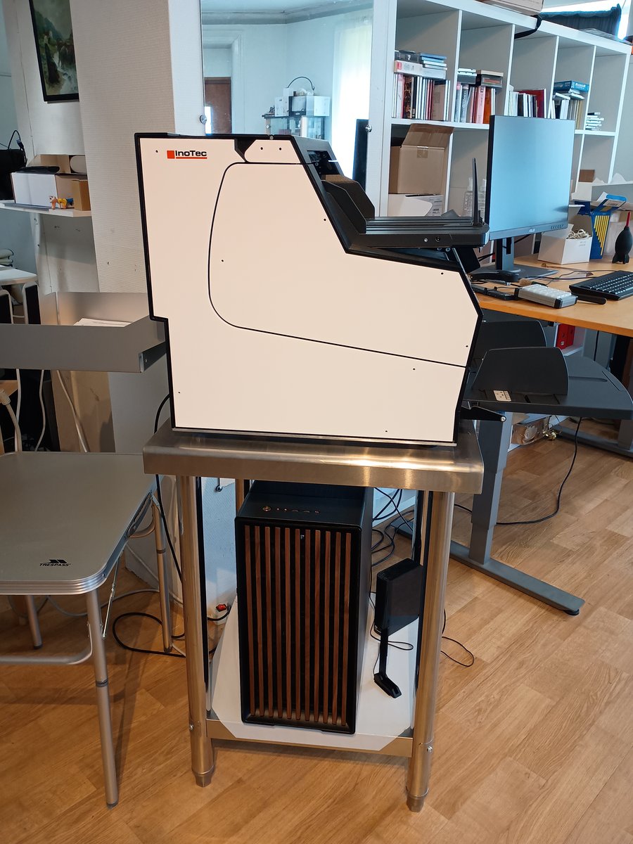 Arkmatad höghastighetsskanner Inotec Scamax 6x1 på ett stålbord, med den nya scannerdatorn på hyllan under